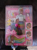 Front of Barbie leopard rainbow hair doll packaging showing doll, accessories, and hair styling tools