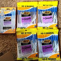 Photo showing one box of 10 blue BIC Cristal pens and four yellow header card packs each containing 12 pens