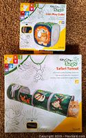 Photo of Kitty City Jungle Lion Play Cube and Safari Tunnel cat toys in original packaging on carpeted floor