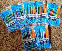 Seven sealed packages of PaperMate Write Bros mechanical pencils on carpet background. Each pack contains 10 mechanical pencils with assorted bright colors.