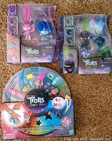 Two Trolls World Tour character figurine sets and one circular sticker activity kit in original packaging.