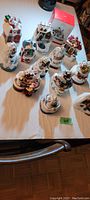 Overview of 13 different Hallmark Keepsake Christmas ornaments depicting various snowy village scenes with light and motion features.