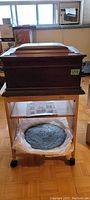 Closed oak music box on table with disks visible below