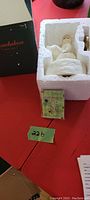 Snowbabies music box with original box, packaging, and winding key visible.