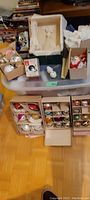 Wide view showing multiple boxes of vintage glass Christmas ornaments and crocheted angel tree topper bundled on a plastic bin.