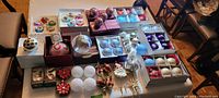 Overhead view of all 39 Christmas ornaments displayed on table showing boxed and loose decorations
