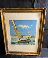 Full view of framed sailing print showing colorful boats on water and decorative gold frame with some chipping.
