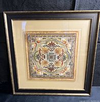 Framed print displayed upright on black fabric background showing entire frame and artwork.
