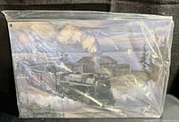 Metal sign in original plastic wrap showing full artwork of a steam locomotive in a rural station scene.