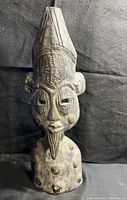 Full frontal view of wooden African tribal mask sculpture, showing the entire figure and detailing.