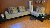 Full view of the sectional sofa set featuring three throw pillows and attached side tables at the ends and middle