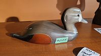 Side profile of the carved wooden Harlequin duck decoy showing painted and stained wood details with a size label 14x5x5.