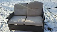 Front view of the two-seater wicker sofa with cushions