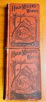Front covers of two volumes of Hugh Miller's Works in reddish-brown hardcovers with black stamped illustrations of fish and plant, titles clear.