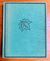 Front cover of the green hardcover book featuring a maple leaf design in black.