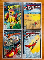 Four Superman comics from the 'Funeral for a Friend' storyline laid out on wooden surface, showing each cover clearly.