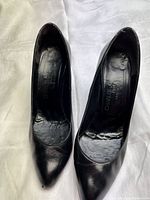 Top view of the black leather pointed toe high heel shoes showing interior branding and condition