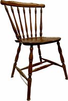 Photo of a solid wood kitchen chair with a spindle back and turned legs, showing the full side and back profile of the chair.