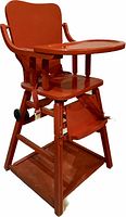 Full view of vintage solid oak wood baby high chair in reddish finish, showing seat, tray, footrest, and structural frame.