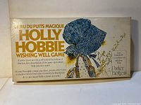 Game box featuring Holly Hobbie illustration on the lid in blue bonnet with floral design, vintage 1976 style.