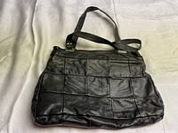 Full exterior view showing the black leather patchwork design and shoulder straps