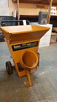 Front view showing yellow steel hopper with Baker 612-3.5HP decal and circular feed chute opening