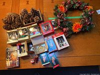 Lot overview showing pinecones, wreath, and multiple boxed ornaments including Angel Chimes box