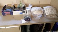 Overview of boxes with small stained glass pieces, beads container, and styrofoam lamp templates