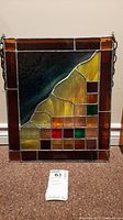Front view of the stained glass art panel showing its full design and hanging chains.