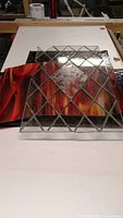 Clear diamond leaded stained glass panel with etched central square over fiery red/orange swirl glass sheets beneath