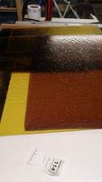 Photo showing stacked pieces of stained glass in yellow, amber, and brown tones with noticeable textures.