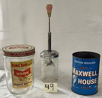 Photo showing three vintage kitchen items: York peanut butter jar, manual food chopper, and Maxwell House coffee can.