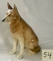 Front left side view of the large vintage ceramic dog figurine showing full body and sitting position