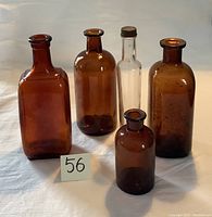 Front view showing all five bottles together on white surface with a number 56 card