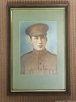 Full view of the framed pastel portrait showing the soldier figure with green mat board and wooden frame.