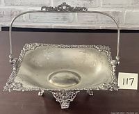 Full view of the Victorian silver-plated bride's basket showing rectangular shape, ornate floral rim, feet, and upright handle.