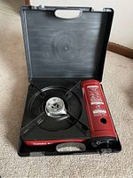Photo showing one Thunder Range portable stove inside carrying case, burner and control knob visible