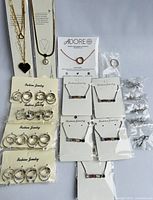 Full lot layout showing multiple pendants, rings, earrings on display cards and packages.