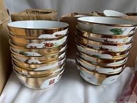 Stacked porcelain bowls with gold rims showing varying Chinese patterns including dragons and floral designs.