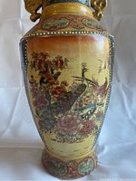 Front side showing birds and floral scene with ornate border and gold-tone handles