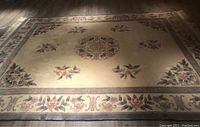 Full view of the large wool area rug showing central medallion and floral design.