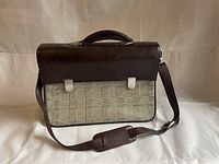 Front view of leatherette briefcase with dark brown flap and plaid front panel showing clasps and shoulder strap.