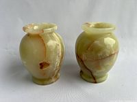Front view of two natural stone vases showing vein patterns and flared lips