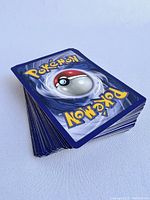 Stack of Pokemon cards showing the backs with Pokeball design in blue and white.