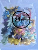 Photo of 24 Pokémon mini figurines in a sealed bag with a visible 24 PCS marking.