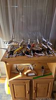 Wide view of assorted airline model planes displayed on a wooden cabinet, including large and smaller aircraft models, some mounted on stands