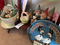 Photo showing a mixture of decorative items including gnomes, a henhouse, and various small pottery pieces.