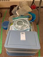Various plastic food storage containers in multiple shapes and sizes, stacked inside a larger container with a lid.