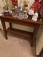 Front view of the wooden hall table with holiday decorations on top.