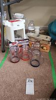 Photo of the Kitchen Wiz blender base, four blending jars with colored bases, Veg-O-Matic food cutter box, and other parts arranged on carpet.